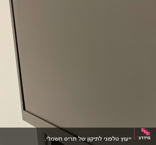 תקריב של תריס מתכת אפור על קיר לבן